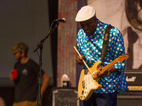 Buddy plays his guitar with a drum stick