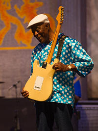 Buddy plays the guitar with his shirt